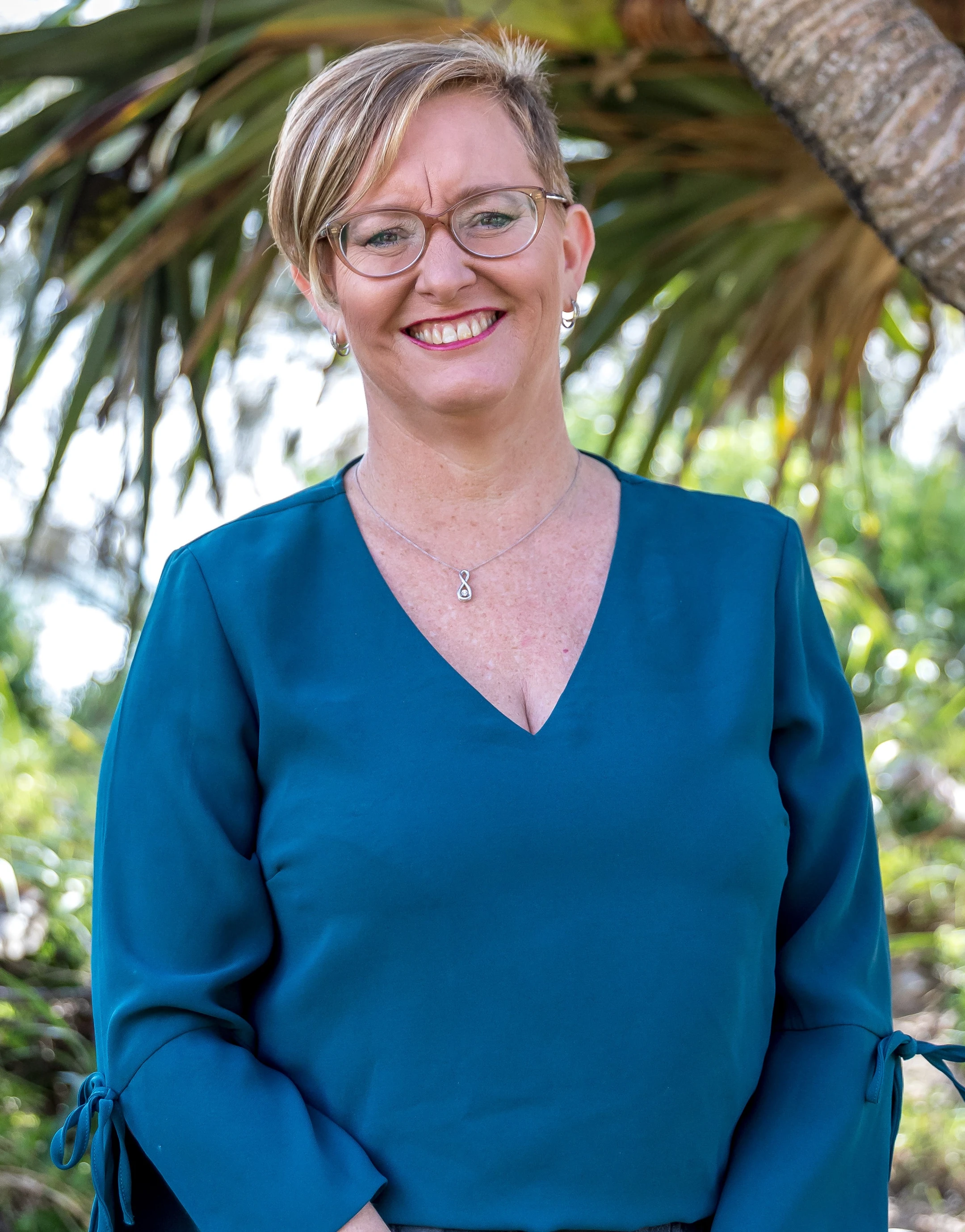 Smiling and professional lady in front of palms